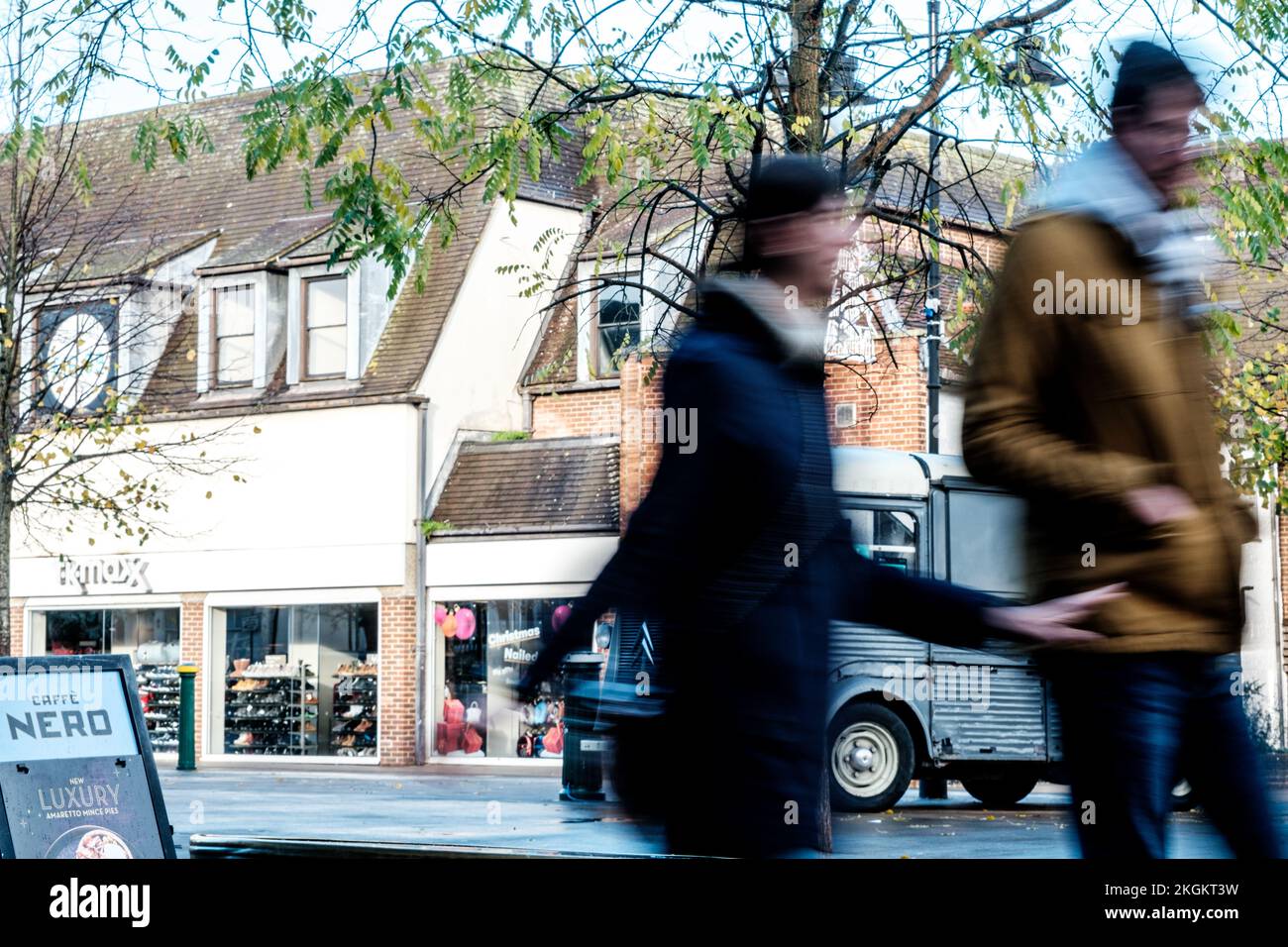 Epsom, Surrey, London UK, November 20 2022, Young Couple Walking Past A Cafe Nero Showing Motion And Movement With Blurred People Against Focused Back Stock Photo