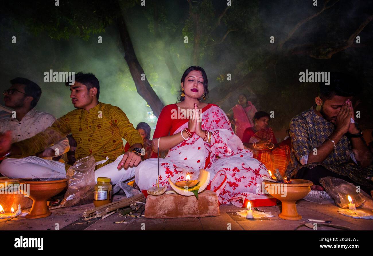 Baradi, Bangladesh, 23/11/2022, Bangladeshi Hindu devotees sit with candles and pray to God at the Shri Shri Lokanath Brahmachari Ashram temple.during the religious festival of Kartik Brati. Thousands of Hindu devotees sit with Prodip and pray to God in front of Shri Shri Lokanath Brahmachar Ashram temple during the Rakher Upobash at Dhaka, Bangladesh. Lokenath Brahmachari, who is called Baba Lokenath, was an 18th-century Hindu saint and philosopher in Bengal. Hindu devotees fast and pray earnestly to the gods for their favors during the ritual called Kartik. Brati, or Rakher Upobash, traditio Stock Photo