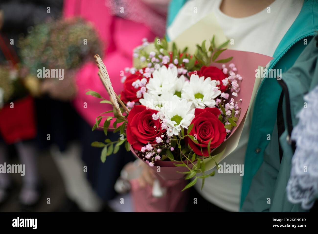 Bouquet of flowers in hands of child. Flowers for holiday. Details of