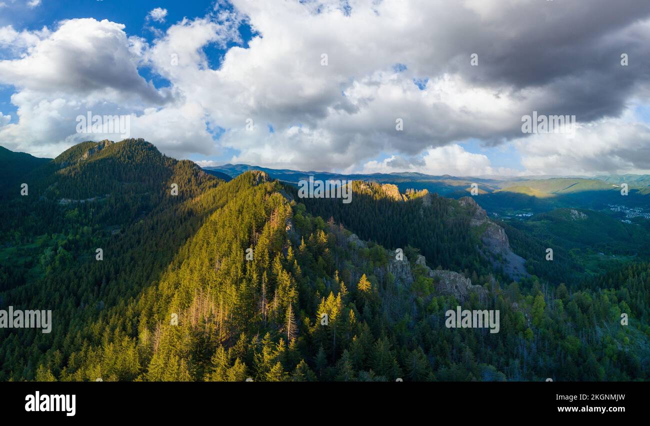 Valley of Balkan mountains with fog, sunny clouds and forests. Village Pamporovo. Panorama, top view Stock Photo