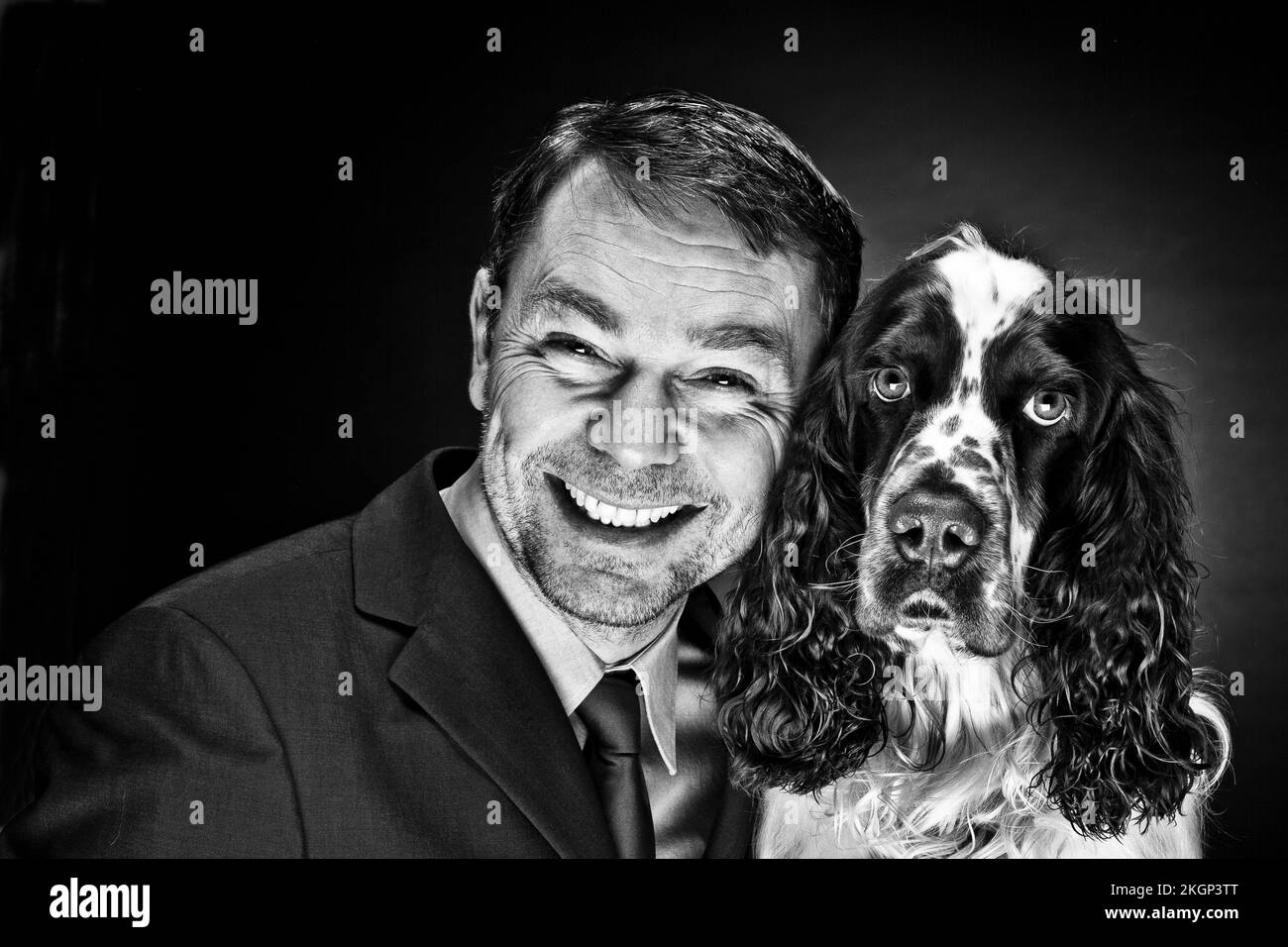 Portrait of mature man with English Springer Spaniel, smiling Stock Photo