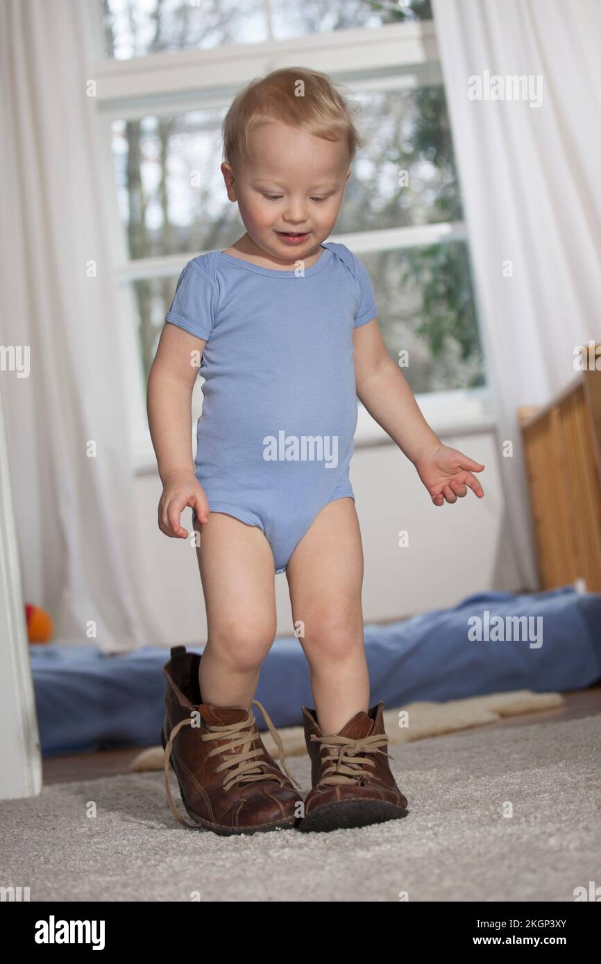 Toddler trying to walk in his father's shoes Stock Photo Alamy