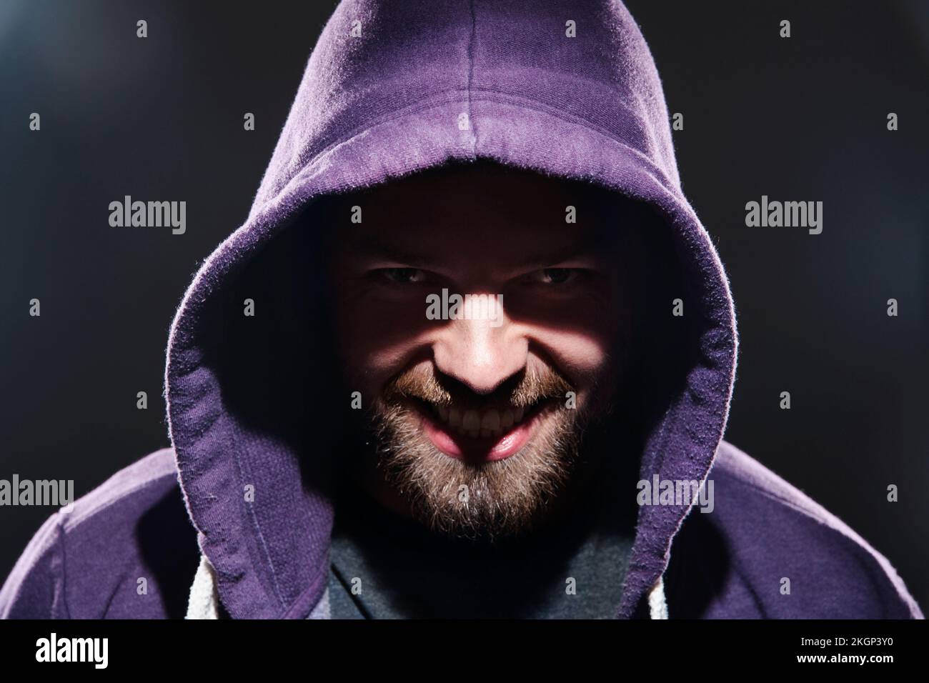 Portrait of man with hooded jacket in front of black background Stock Photo