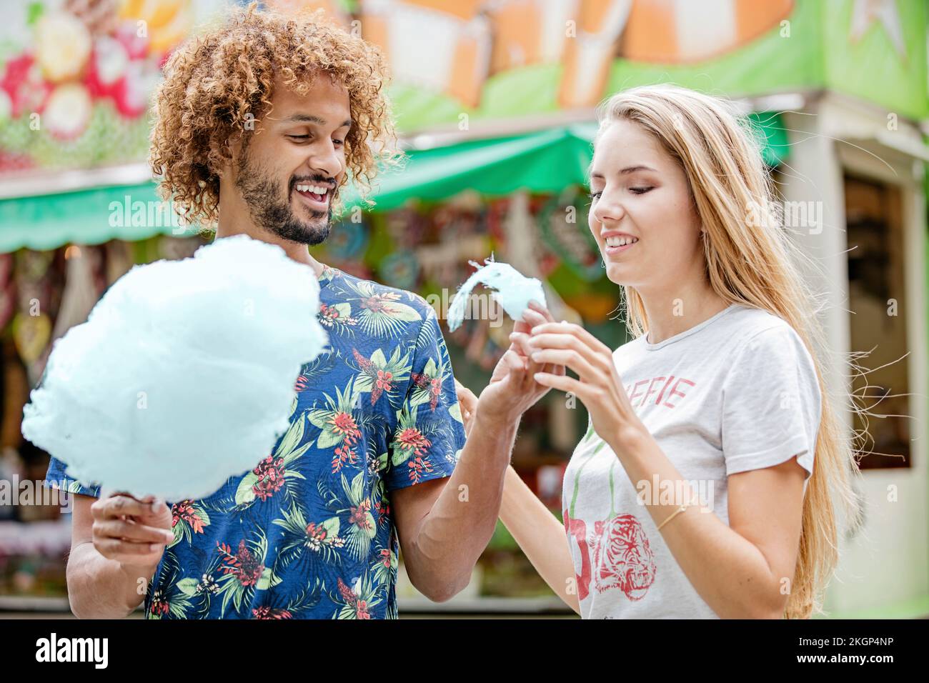 Young couple eating candy floss at a fun fair Stock Photo