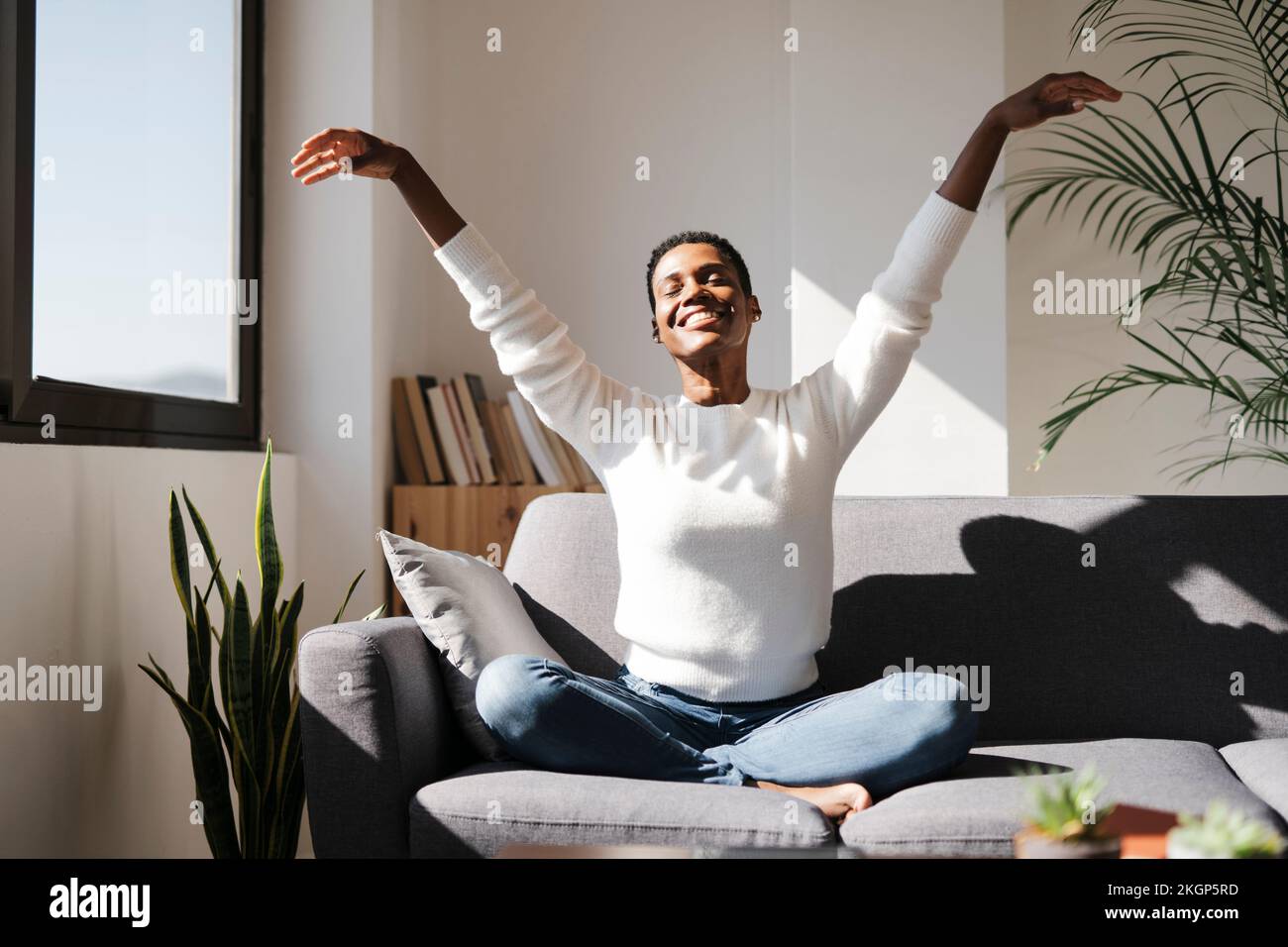 Smiling relaxed woman sitting on couch at home with closed eyes Stock ...