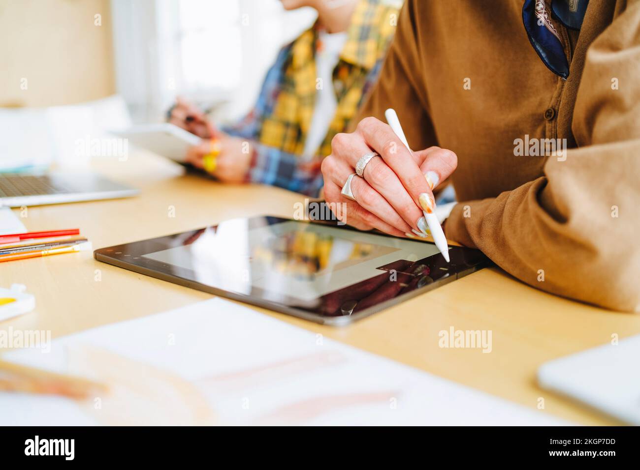 Graphic designer with digitized pen using tablet PC at desk Stock Photo