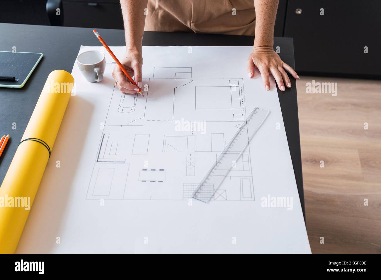 Architect working on blueprint leaning on table Stock Photo
