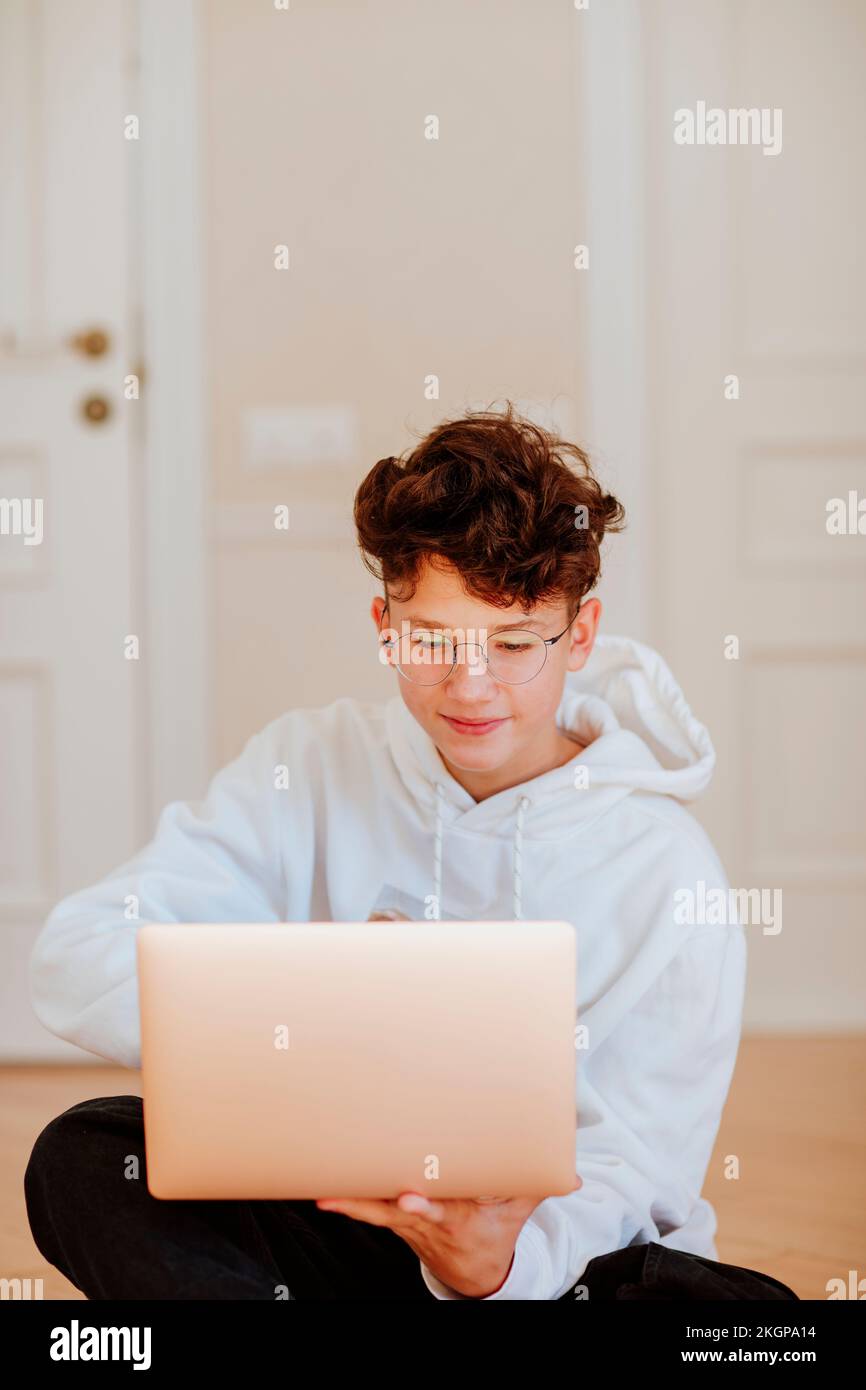 Smiling boy using laptop at home Stock Photo