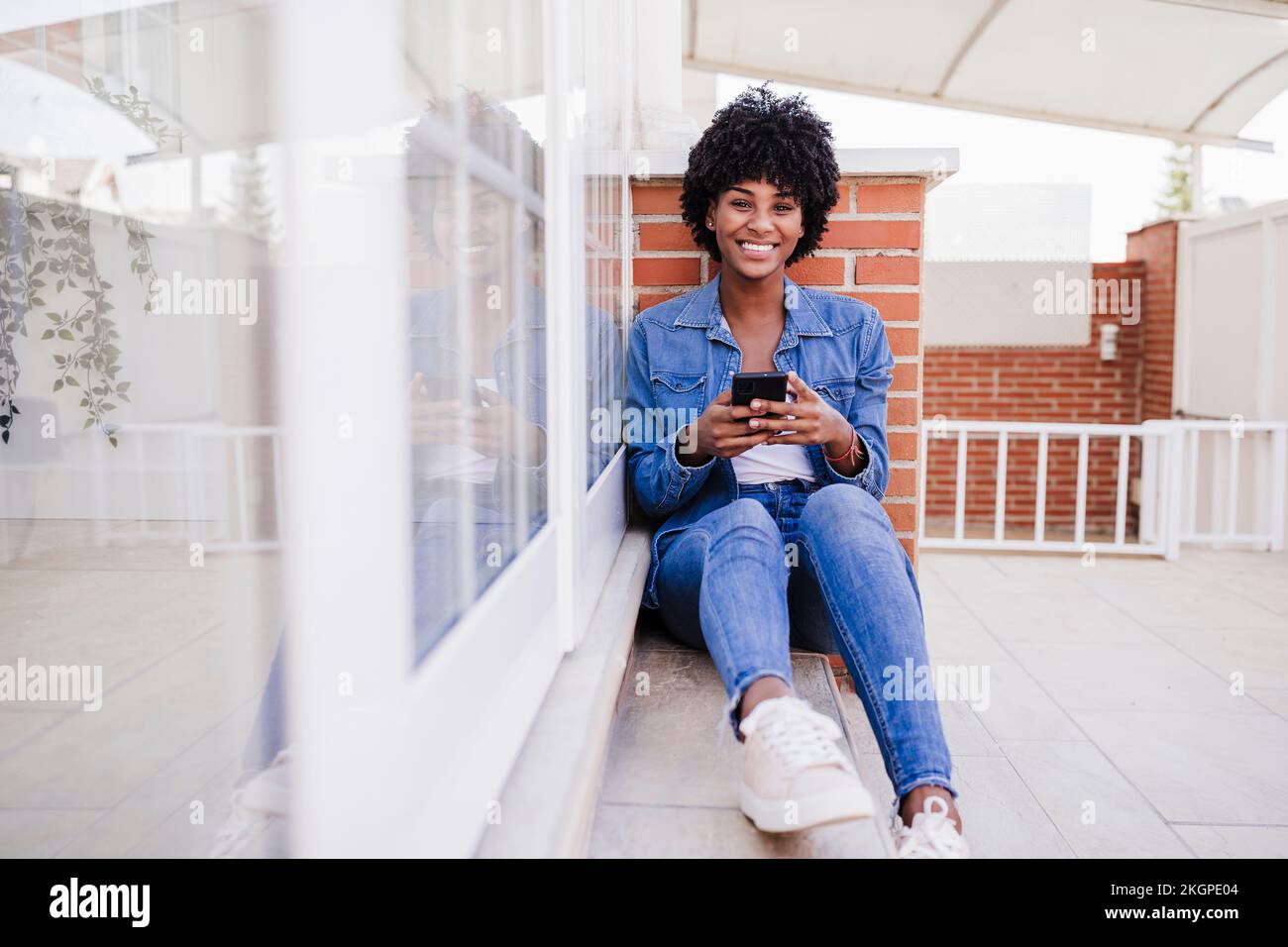 Young woman sitting on porch hi-res stock photography and images - Alamy