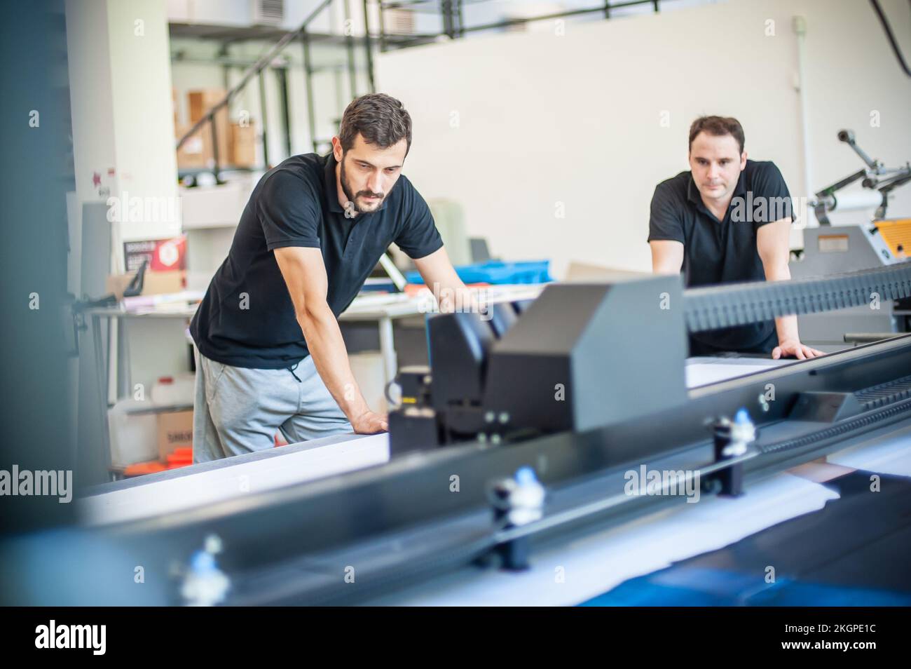 Professional worker printmaker technician operator works in printing