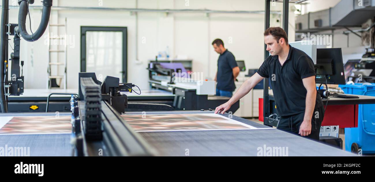 Professional worker printmaker technician operator works in printing