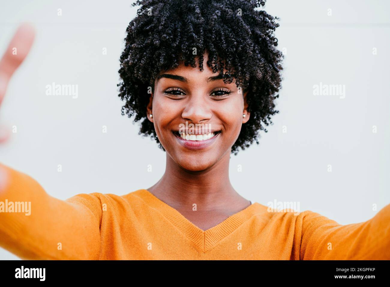 Smiling woman with Afro hair taking selfie Stock Photo - Alamy