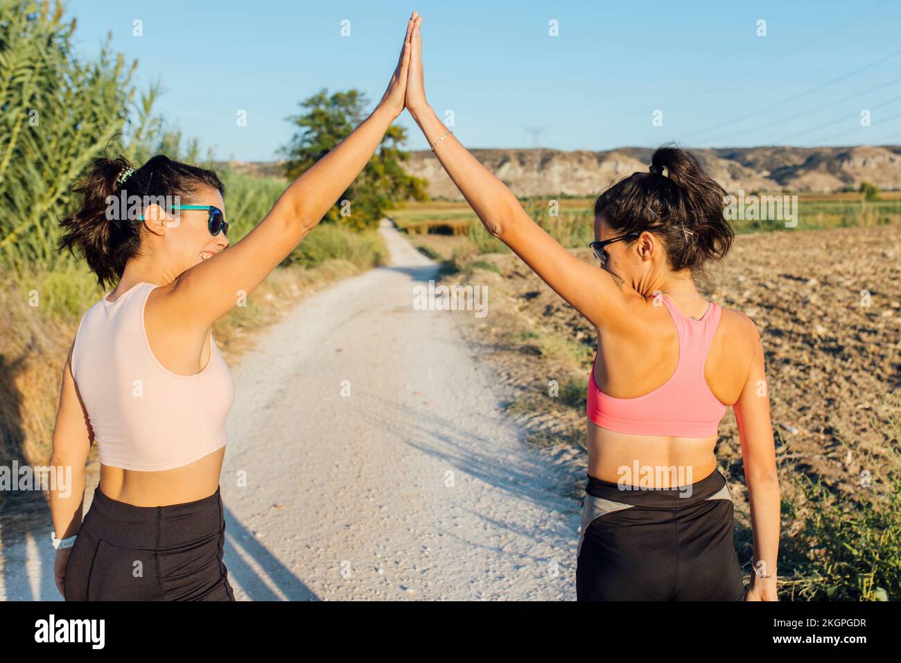 Woman giving high-five to instructor on footpath Stock Photo