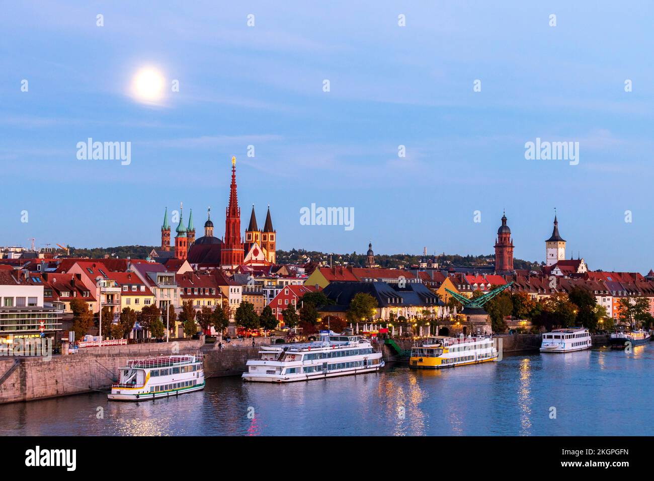 Germany, Bavaria, Wurzburg, Moon glowing over river Main with Wurzburg Cathedral and Marienkapelle in background Stock Photo