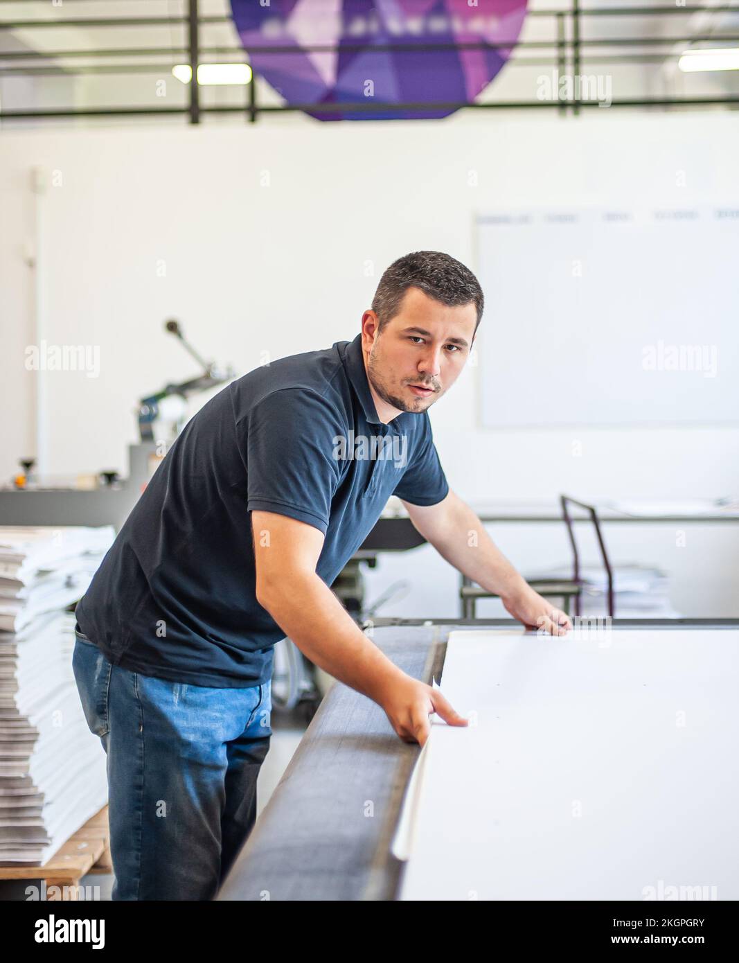 Professional worker printmaker technician operator works in printing