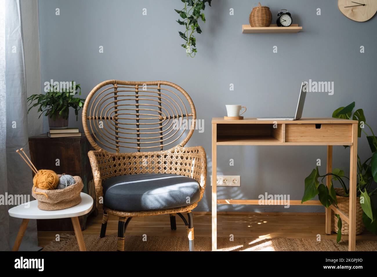 Ball of wool in basket on table by chair at home Stock Photo