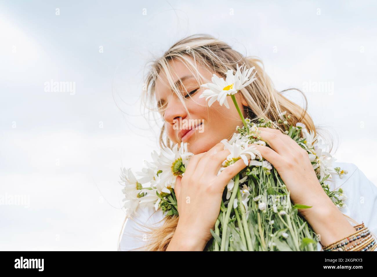 Smiling woman with eyes closed holding bunch of flowers Stock Photo - Alamy