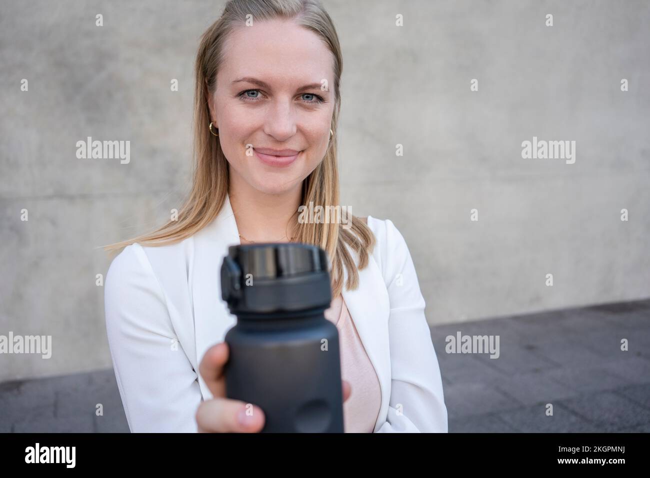 Blond smiling woman showing water bottle Stock Photo