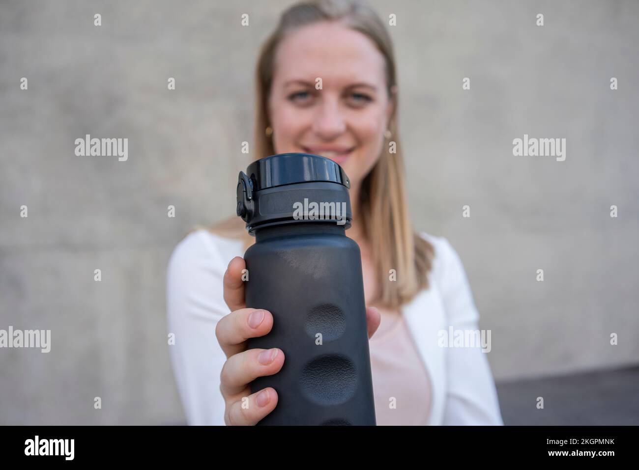 Young swoman showing reusable water bottle Stock Photo