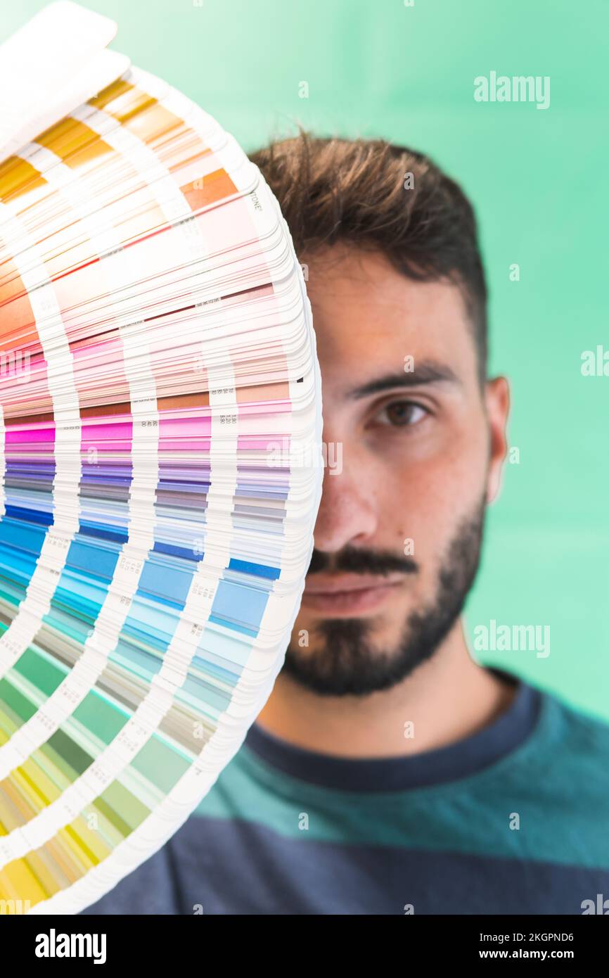 Young graphic designer with color swatch in front of face Stock Photo