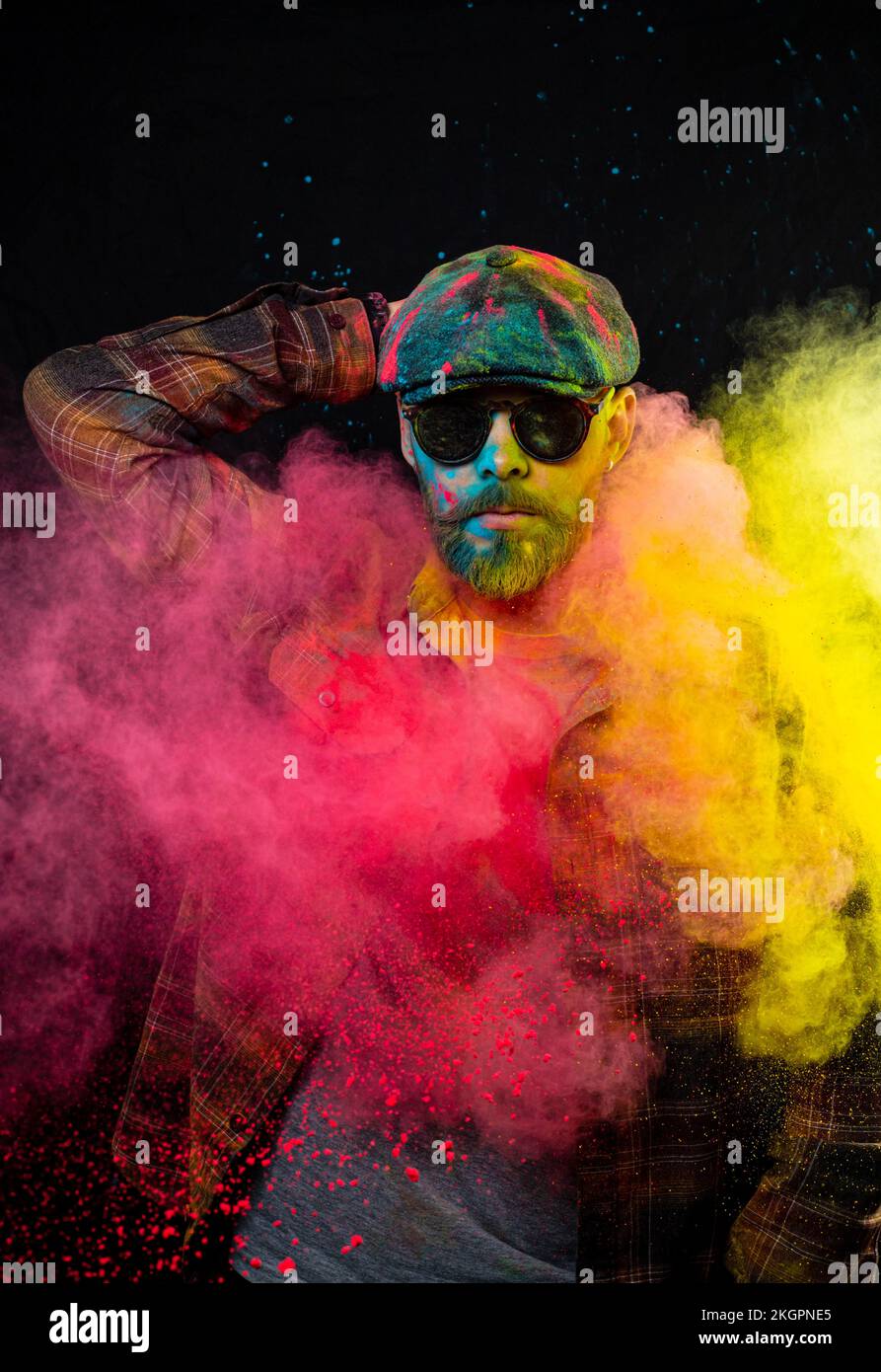 the guy in the cap and glasses is covered with colored paints Stock Photo