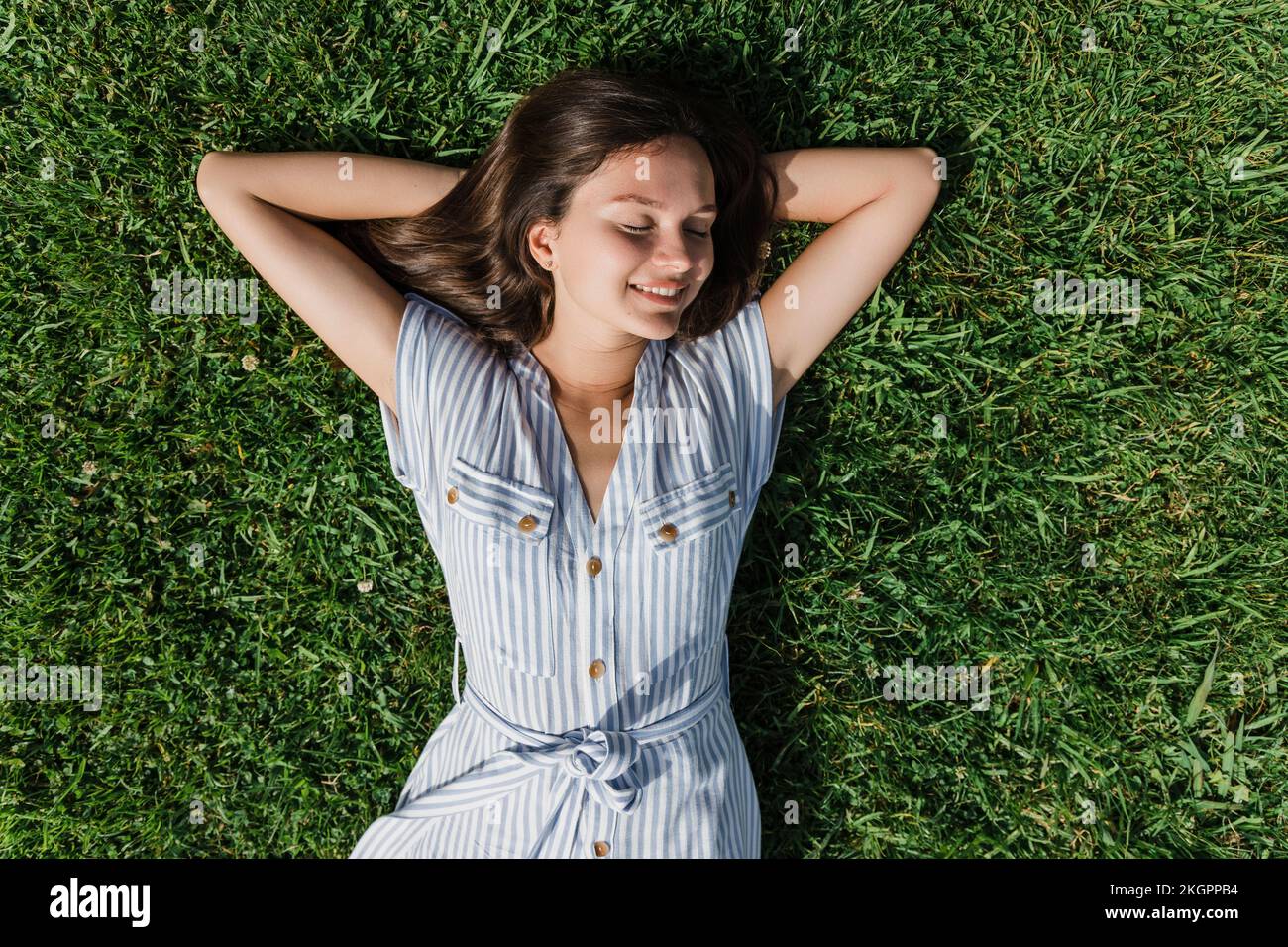 Happy young woman with eyes closed relaxing on grass Stock Photo - Alamy