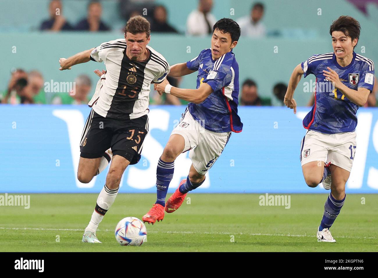 Doha, Qatar. 23rd Nov, 2022. Thomas Mueller (L) of Germany vies with Endo Wataru (C) of Japan during the Group E match between Germany and Japan at the 2022 FIFA World Cup at Khalifa International Stadium in Doha, Qatar, Nov. 23, 2022. Credit: Cao Can/Xinhua/Alamy Live News Stock Photo