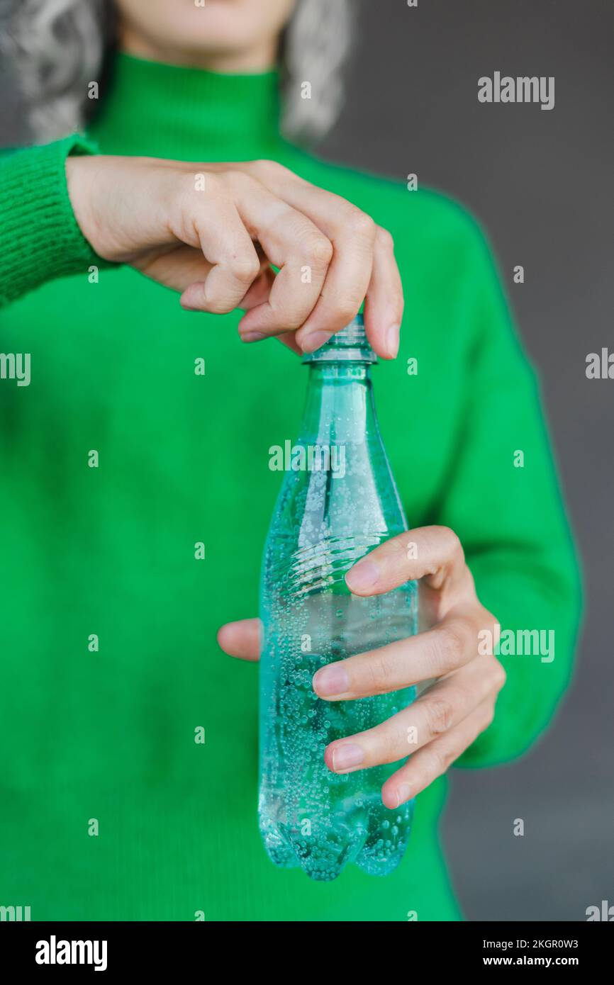 Woman opening plastic water bottle Stock Photo