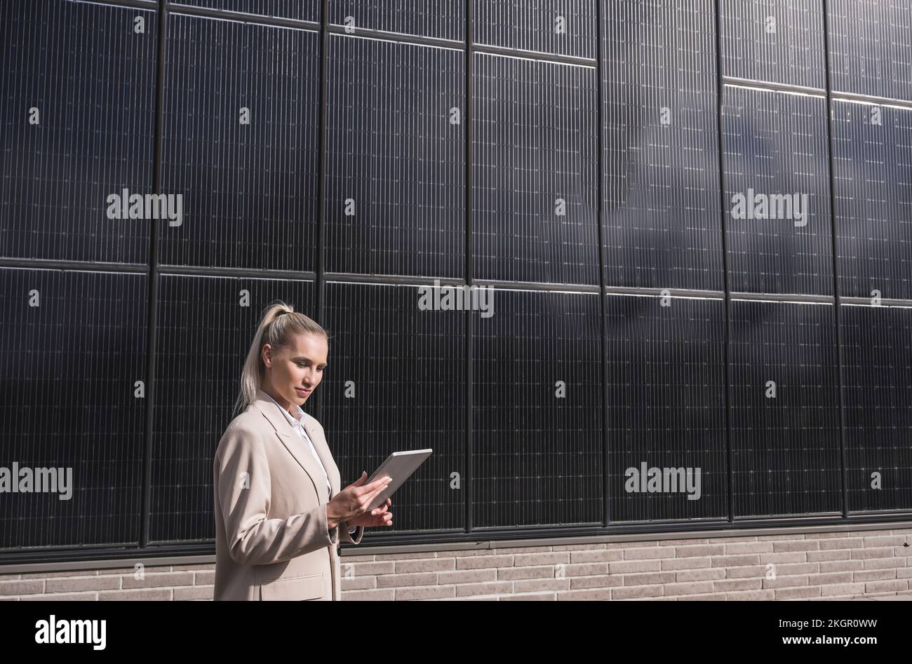 Businesswoman using tablet PC in front of solar panels Stock Photo