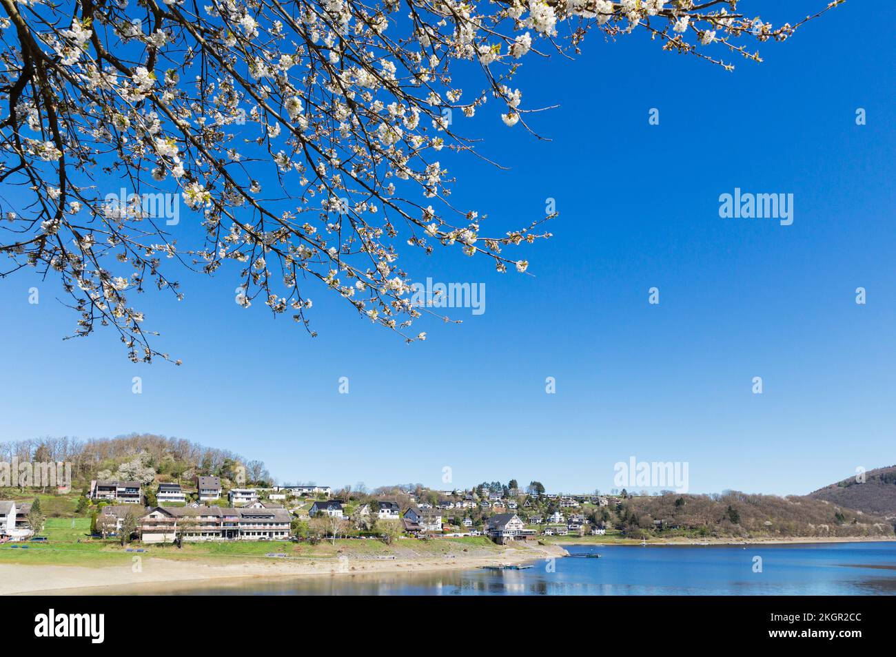 Village in front of lake under blue sky Stock Photo - Alamy