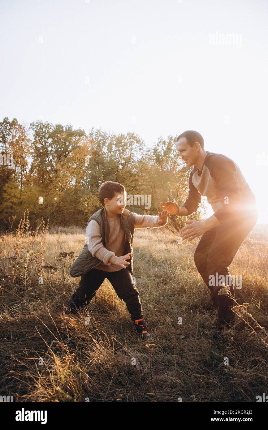 Happy father playing with son on field Stock Photo