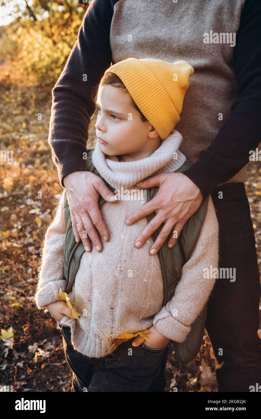 Boy wearing knit hat standing with father Stock Photo