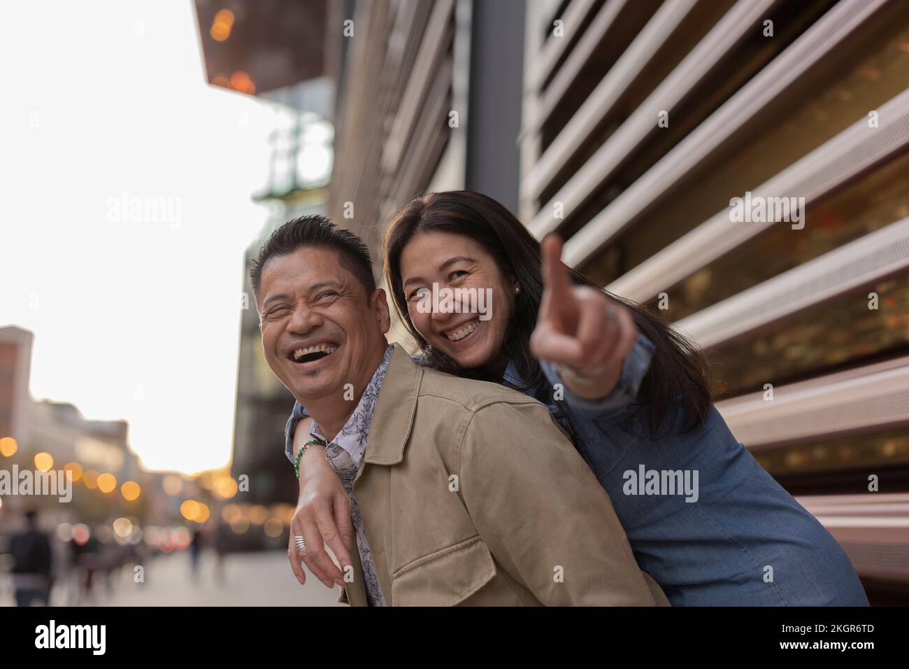 Happy mature couple having fun outside building Stock Photo