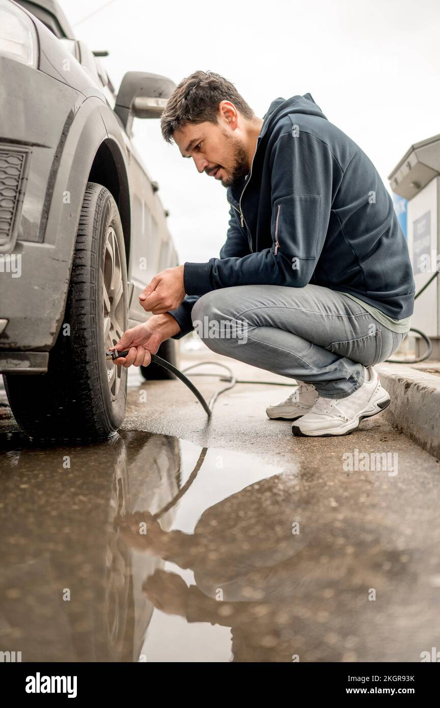 Man filling air in tire at gas station Stock Photo Alamy