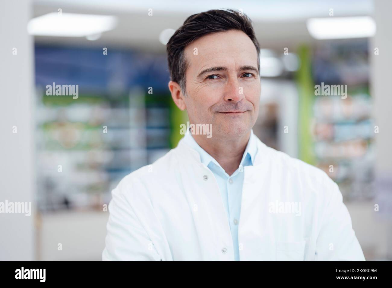 Smiling pharmacist wearing lab coat in pharmacy Stock Photo Alamy