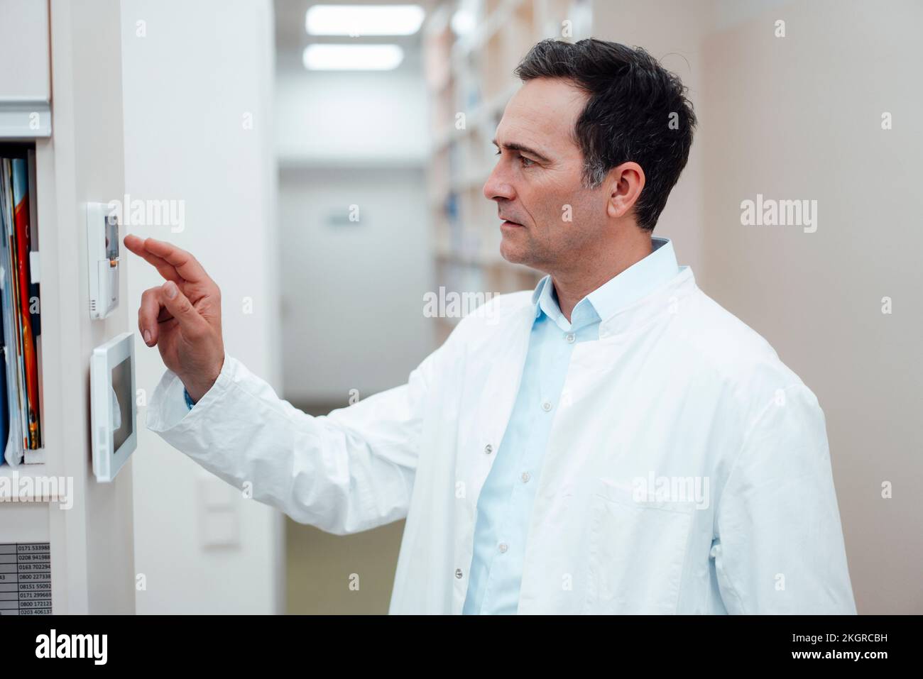 Pharmacist using security system in pharmacy Stock Photo - Alamy