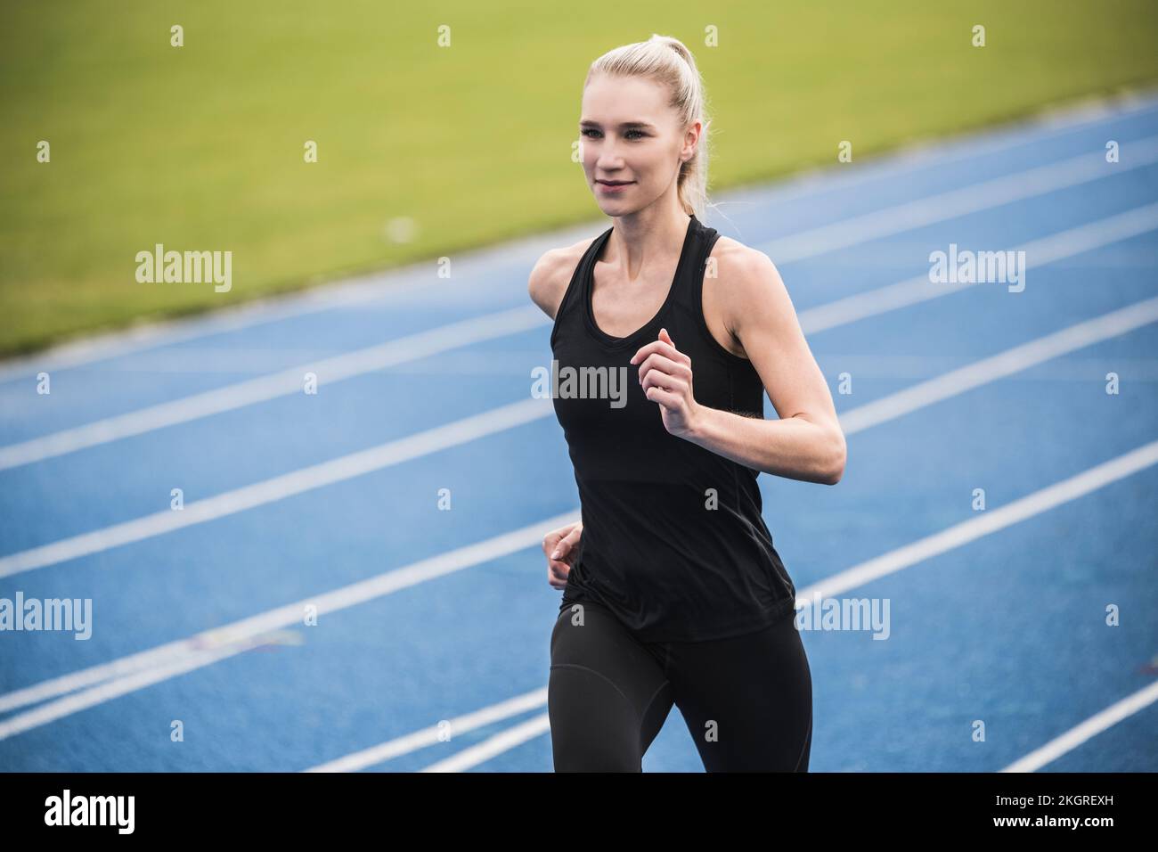 Smiling young athlete running on track Stock Photo Alamy