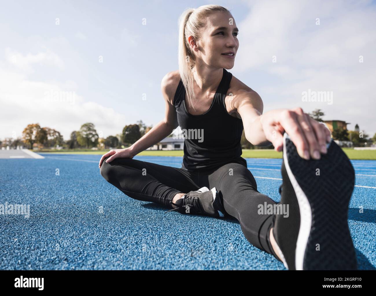 Athlete doing warm up exercise on running track Stock Photo Alamy