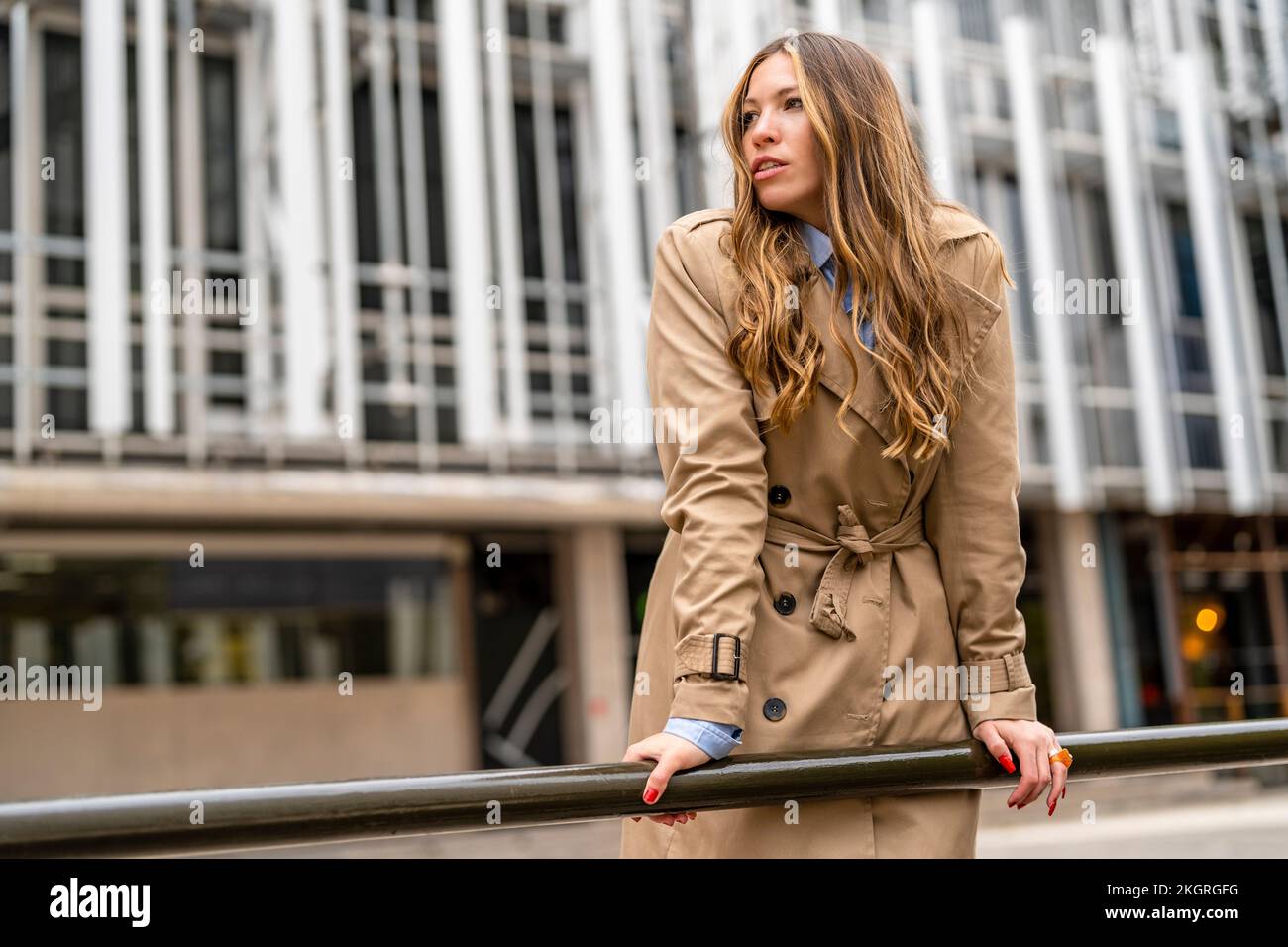 Businesswoman leaning on railing in front of building Stock Photo