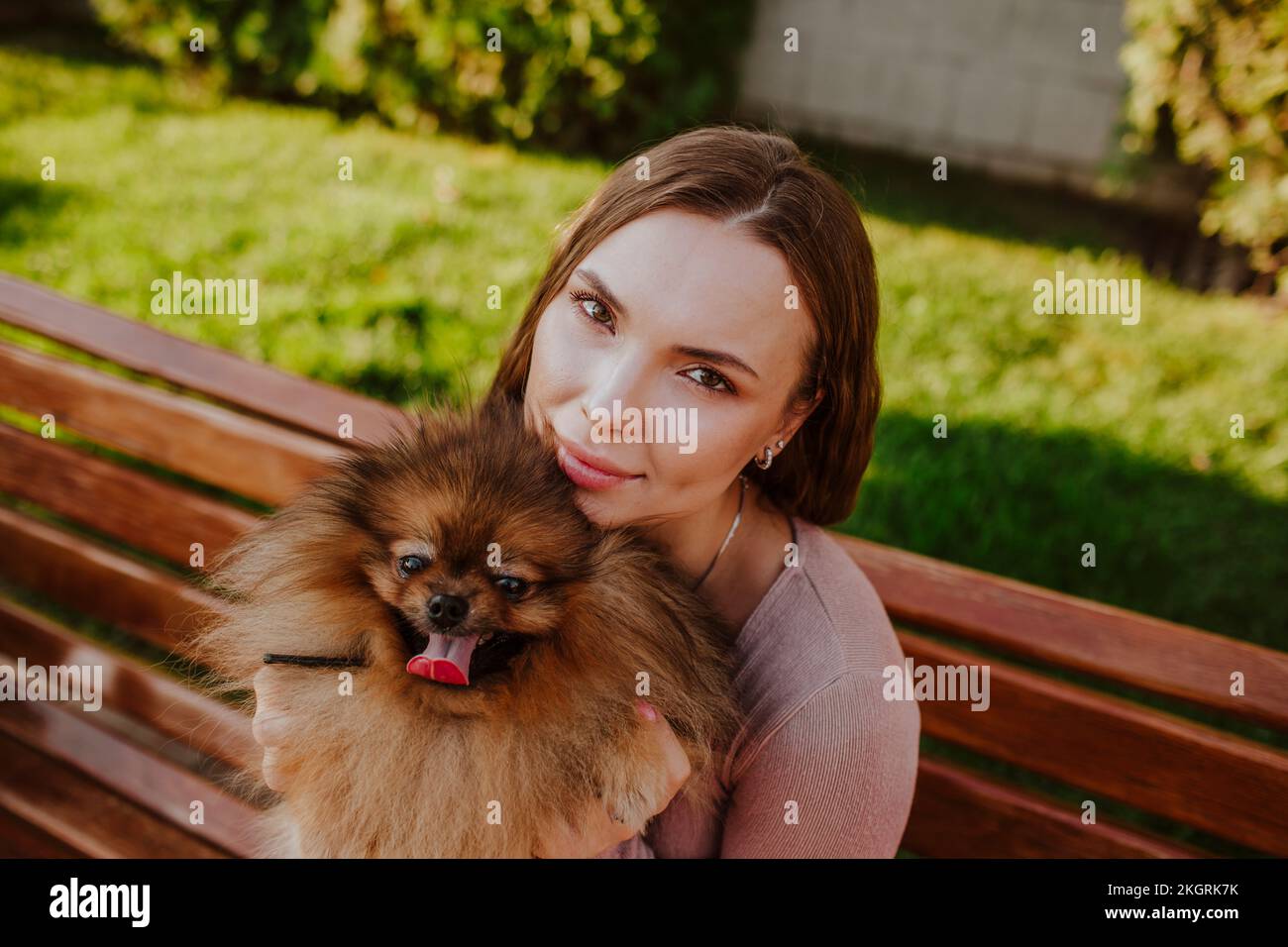Smiling woman sitting with dog on bench Stock Photo - Alamy
