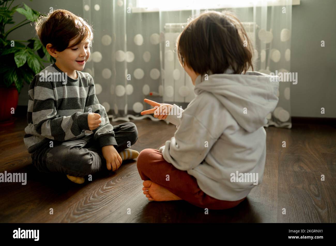 Brothers playing rock paper scissors on floor at home Stock Photo Alamy