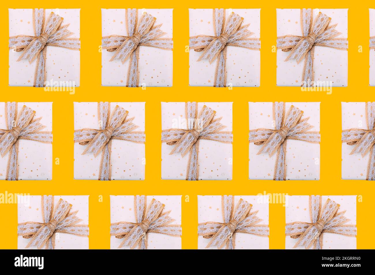 Multiple image of gift boxes wrapped in white paper against yellow background Stock Photo
