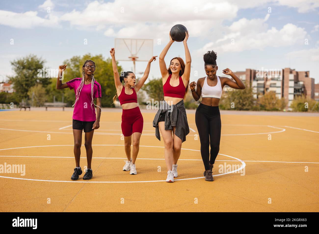 Happy young woman walking with basketball in sports court Stock Photo ...