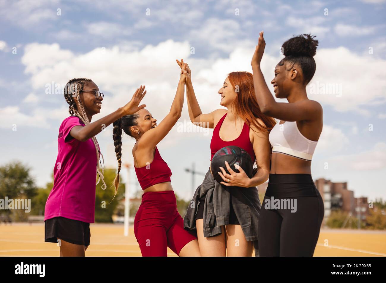 Happy multiracial friends doing high five in sports court Stock Photo ...