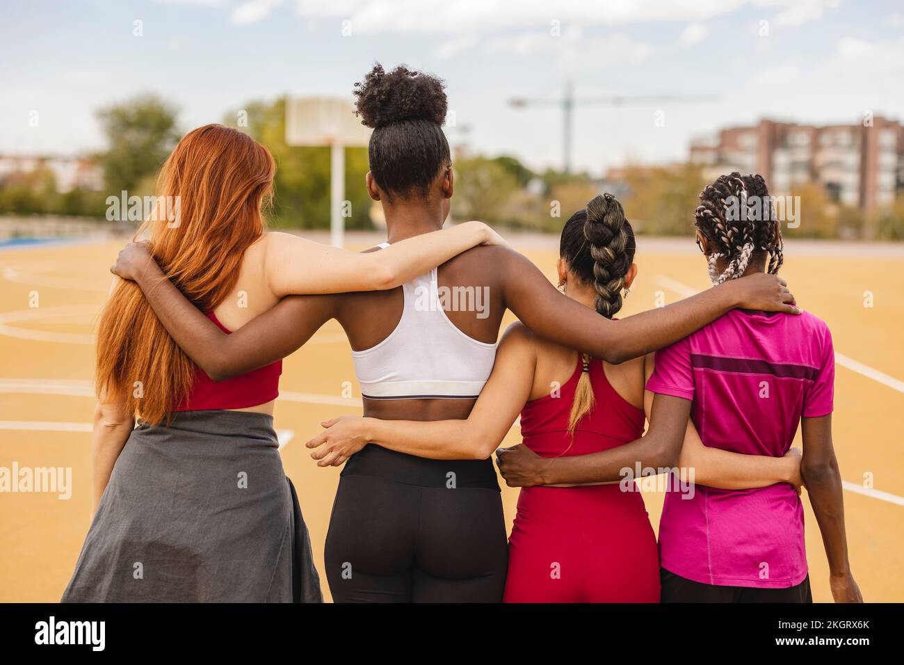 Friends standing with arms around in sports court Stock Photo - Alamy