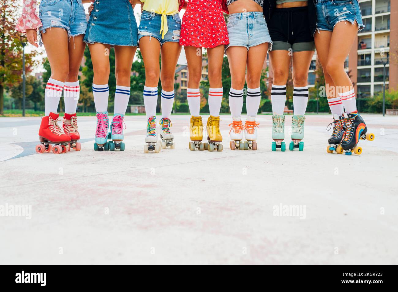 Legs of women in roller skates standing side by side at sports court