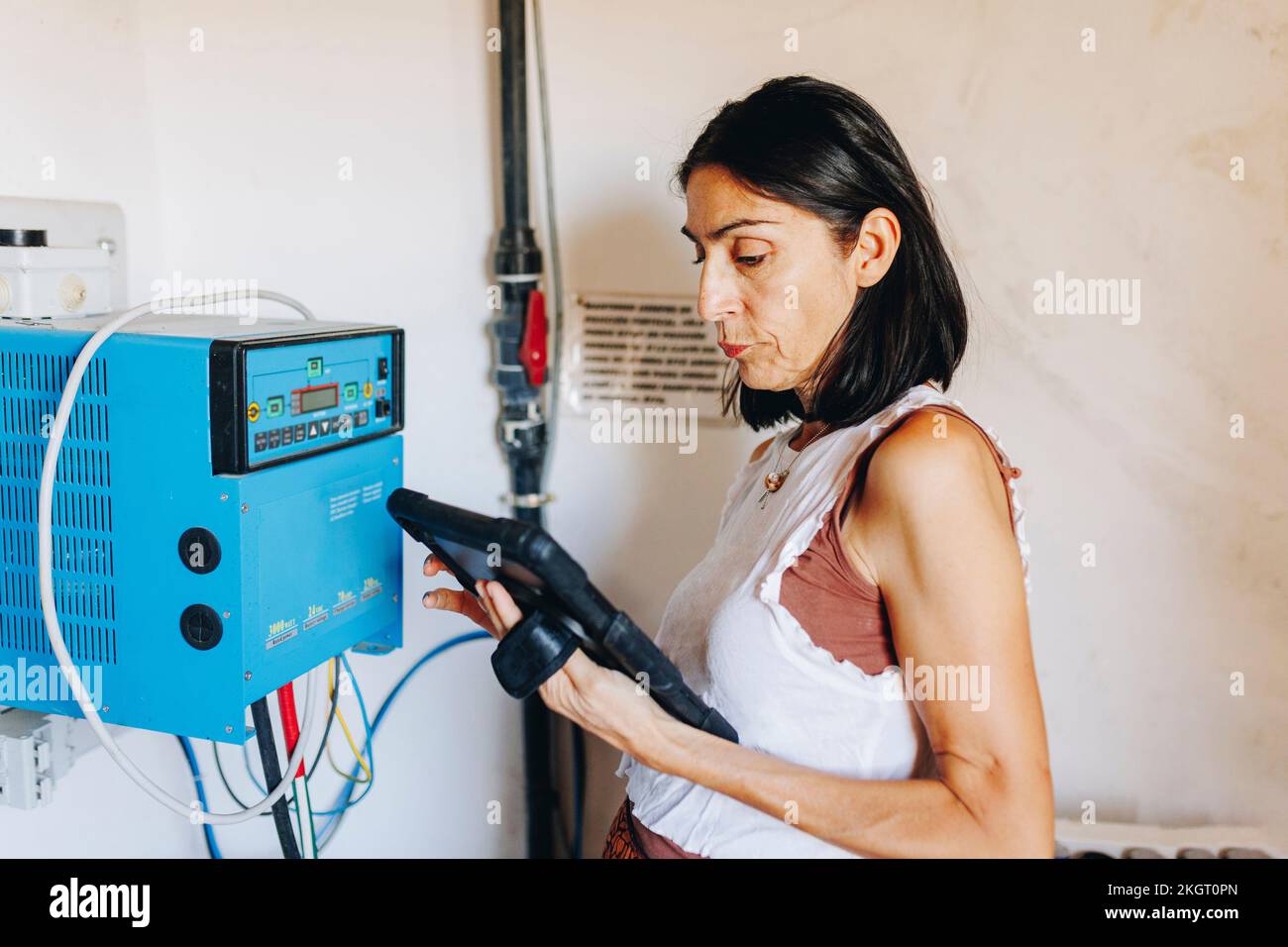 Mature woman using tablet PC by inverter at solar power station Stock Photo