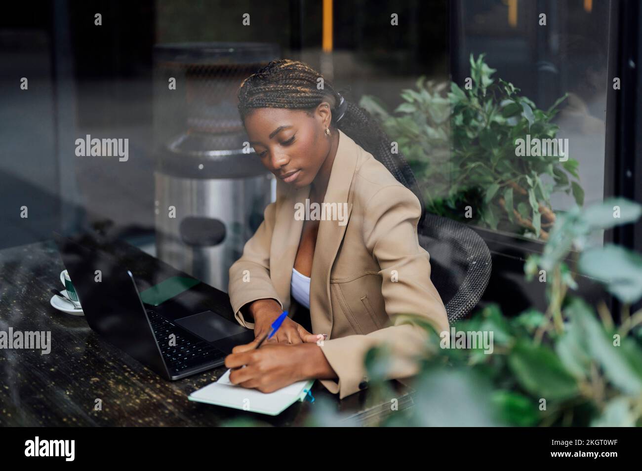 Young businesswoman making notes at cafeteria Stock Photo
