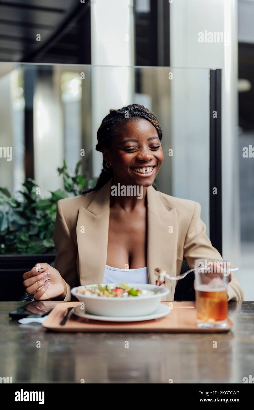 Cheerful woman having food at cafe Stock Photo