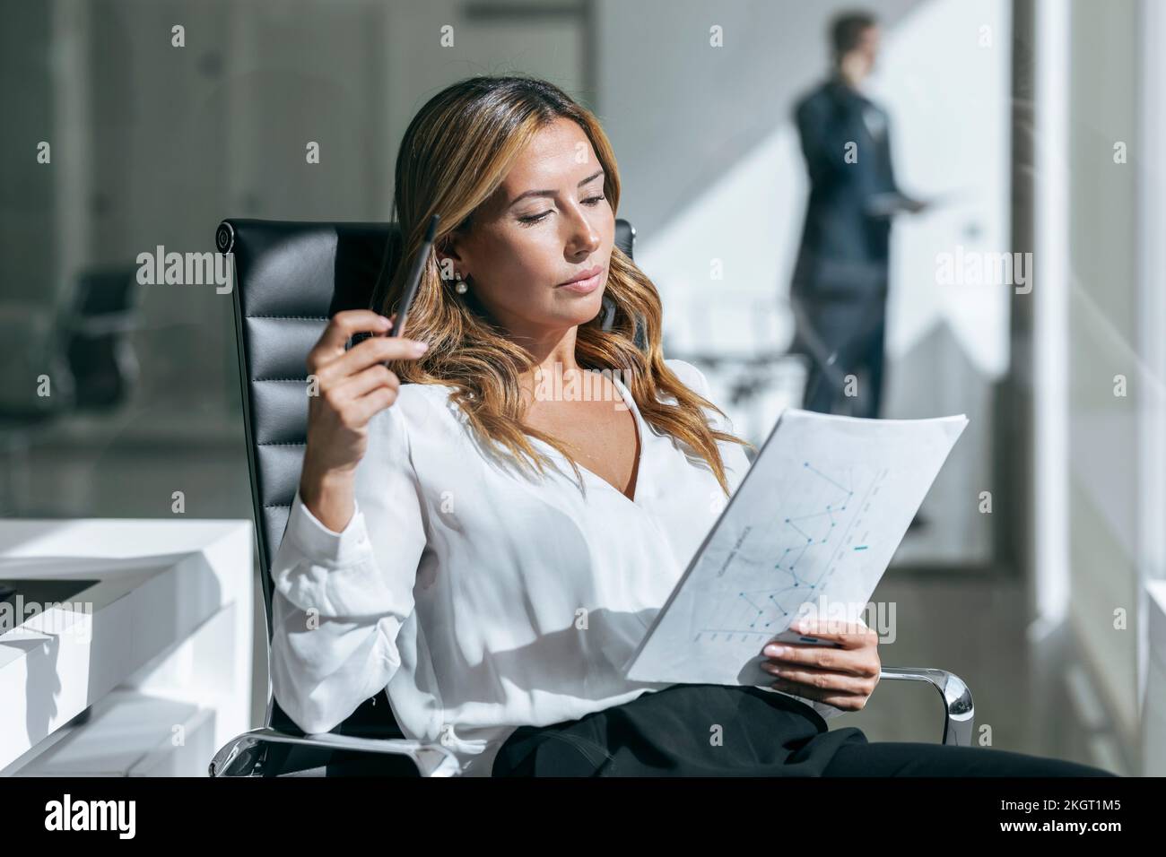 Businesswoman reading document in office Stock Photo